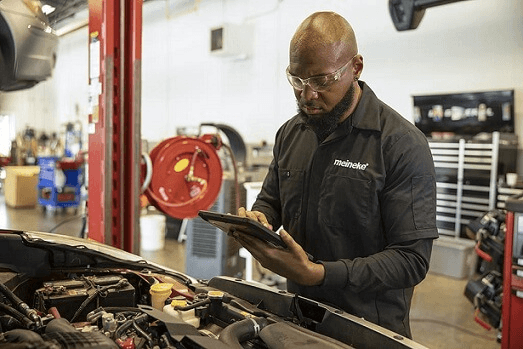 A Meineke technician performing a car diagnostic test