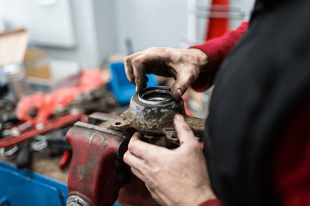 A wheel bearing replacement done by a technician in an auto repair shop